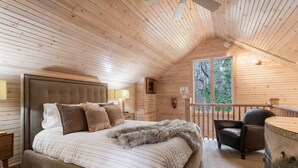 Un dormitorio acogedor con una cama grande, una silla y vistas al exterior por una ventana.