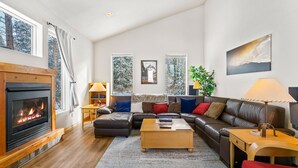 Ein geräumiges Wohnzimmer mit Kamin, Ledersofa und Couchtisch.