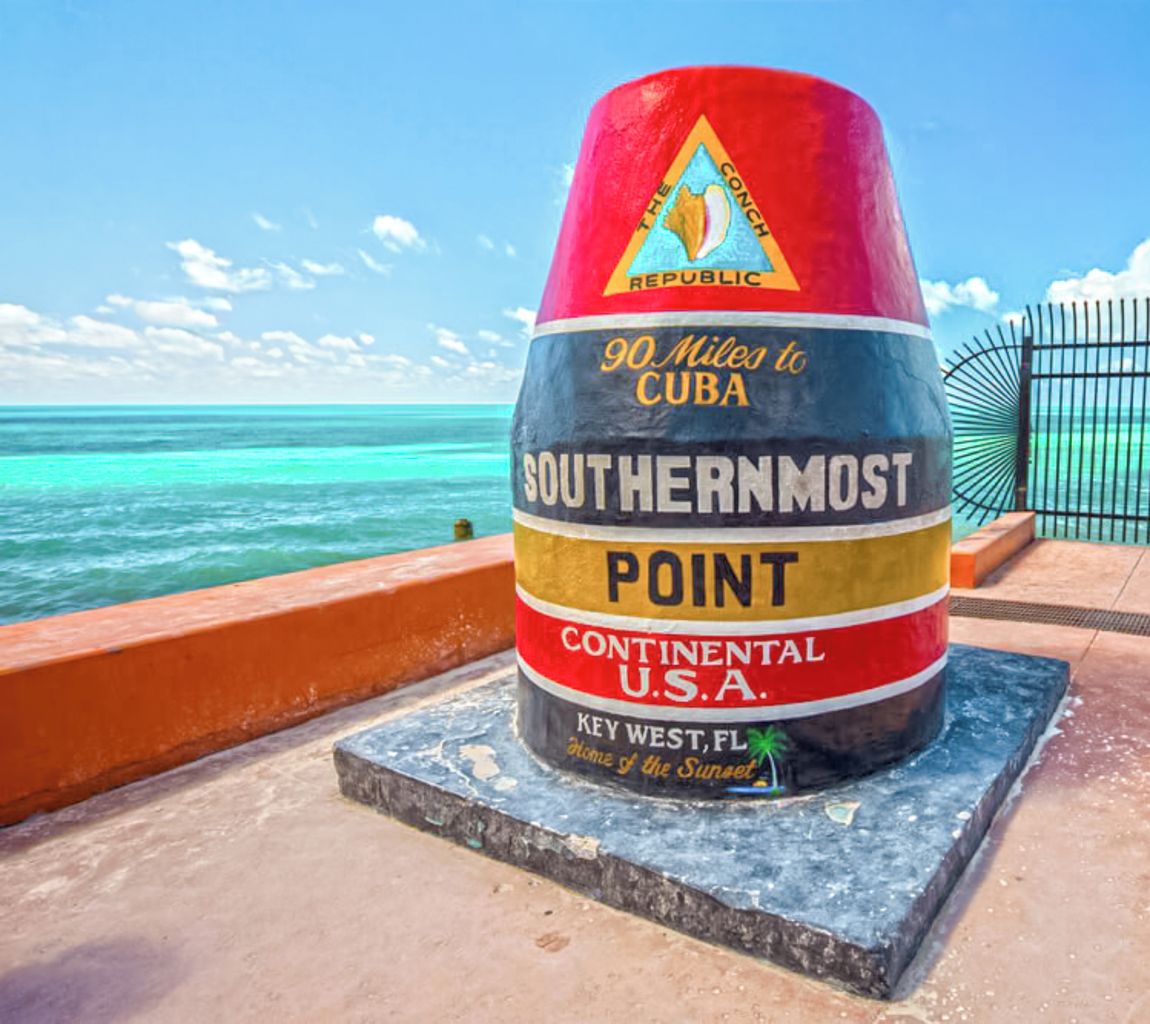 Un marcador grande y colorido que dice '90 Millas a Cuba' en el punto más austral, Key West, FL.
