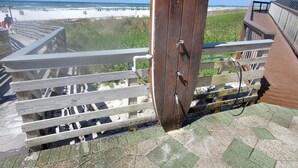 Eine Holzterrasse mit Blick auf Strand und Meer.