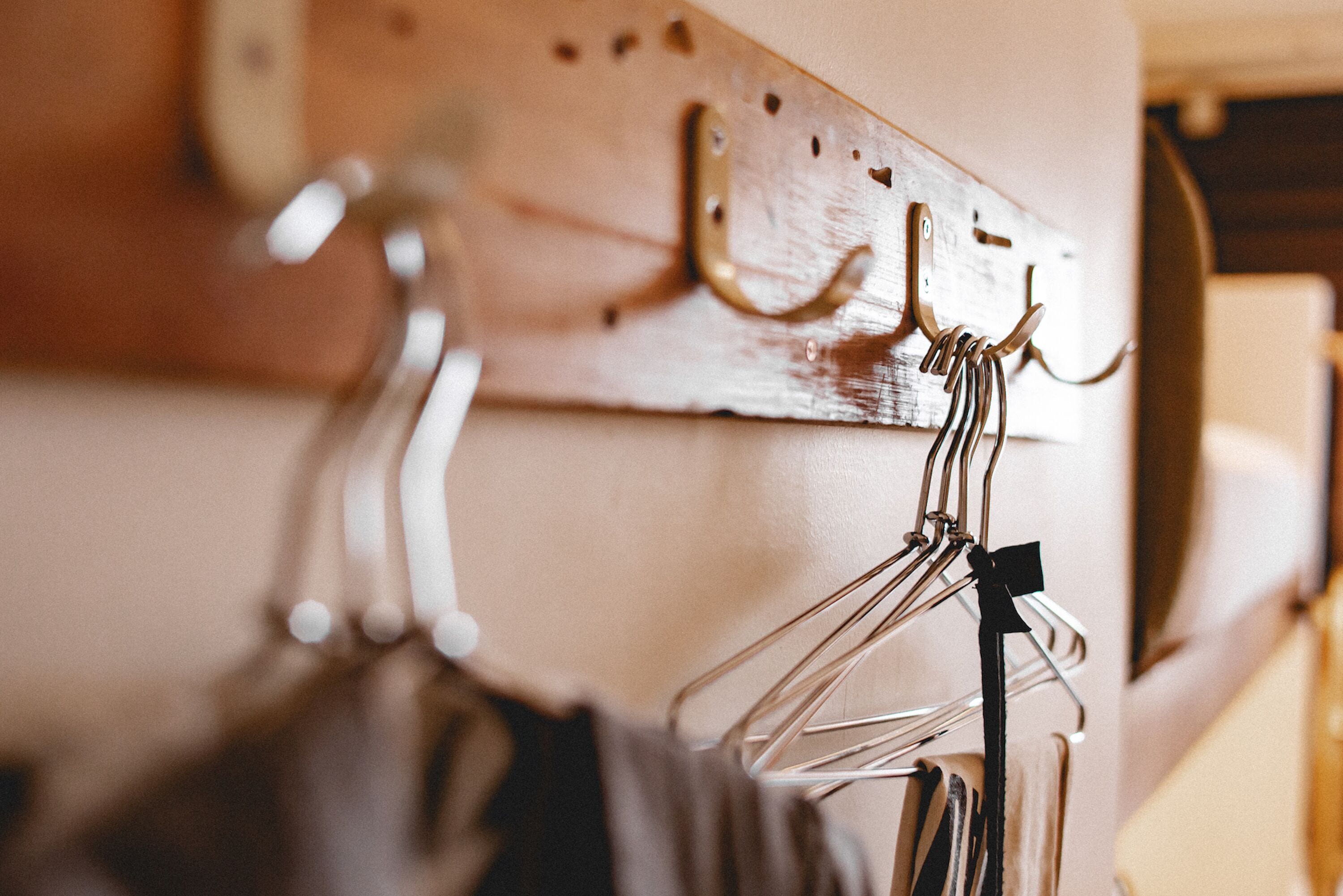 A wooden wall with metal hooks for hanging items.
