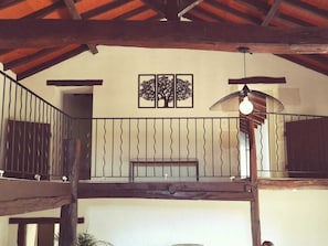A wooden balcony with a wrought iron railing, a hanging light fixture, and a wall-mounted artwork. - Sleeps 13/15, 270 m2 house with swimming pool / CHEQUES ANCV ACCEPTES (Bonnes)