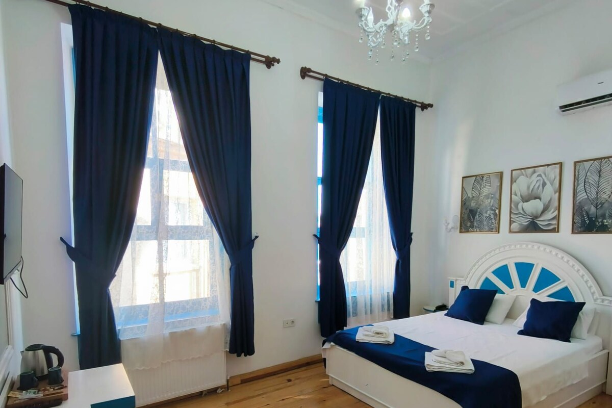 Een slaapkamer met een bed, een bureau en een kroonluchter.