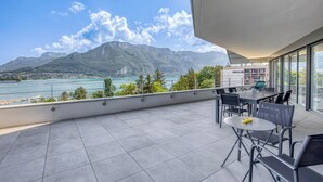 A balcony with a dining table and chairs, overlooking a lake and mountains. - La Cantonade 4* - Breathtaking view of Lake Annecy (Annecy)