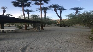 A desert landscape with palm trees and a stone structure. - Westin Desert Willows, Palm Desert (Palm Desert)