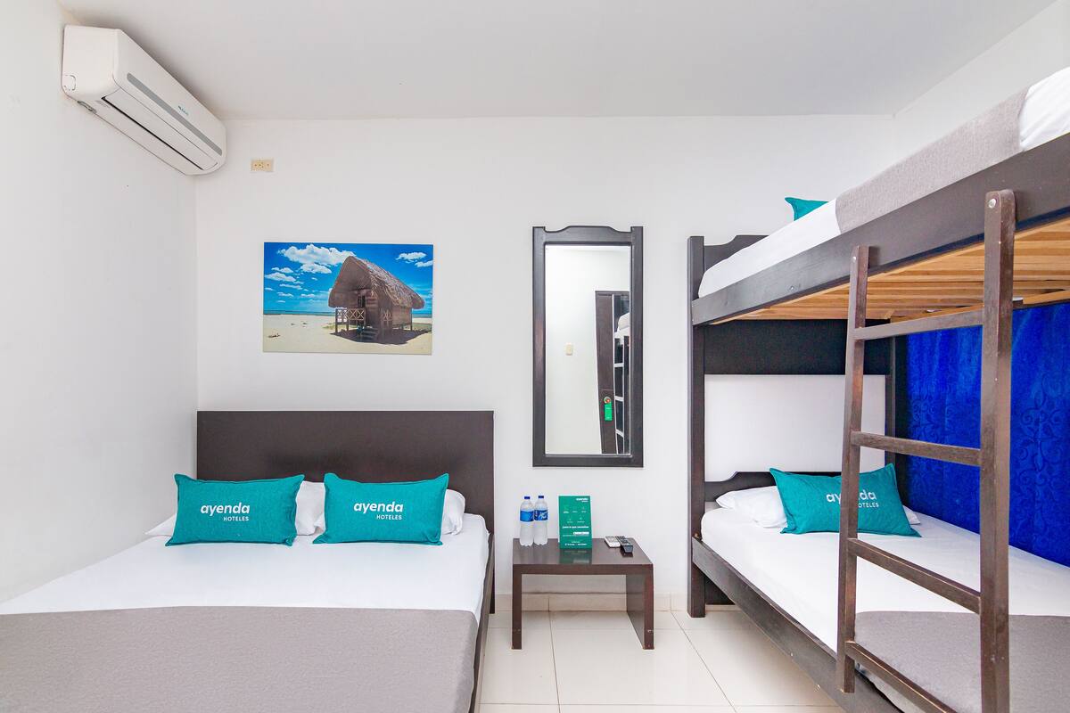 Une chambre d’hôtel avec deux lits, une table de chevet, un miroir et un appareil de climatisation.