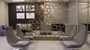 A modern waiting area with contemporary chairs, a decorative wall, and framed artwork. - Polana Plaza Hotel (Maputo)