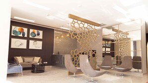 A modern lobby with a reception desk, seating area, and artwork on the walls. - Polana Plaza Hotel (Maputo)