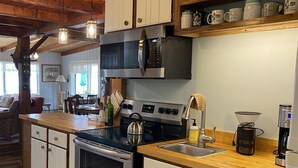 Una cocina con isla central, electrodomésticos de acero inoxidable, armarios de madera y una zona para café.