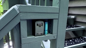 A staircase with a small electrical box and a blue cylindrical object. - Two bedroom upstairs unit. "Timberlane Mountain Retreat" with mini kitchen (Boone)