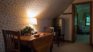 A dining area with a wooden table, chairs, a lamp, and a television. - Two bedroom upstairs unit. "Timberlane Mountain Retreat" with mini kitchen (Boone)