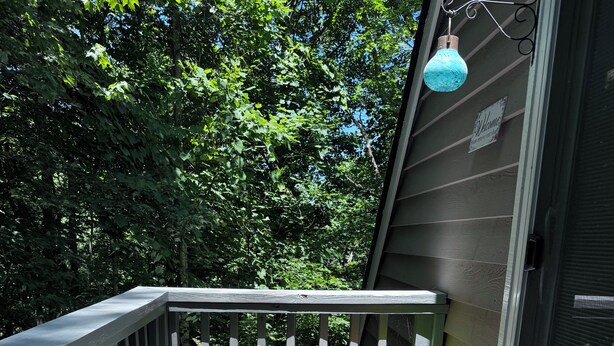 A wooden balcony with potted plants and a welcome sign. - Two bedroom upstairs unit. "Timberlane Mountain Retreat" with mini kitchen (Boone)