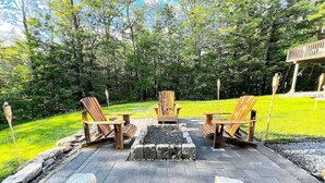 An outdoor seating area with three Adirondack chairs and a fire pit. - Stratton Mountain Home - Hot Tub, Sauna, Fire Pit, & MORE! (Jamaica)