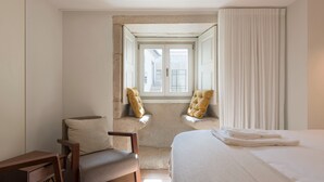 A hotel room with a bed, two armchairs, a small desk, and a window with curtains. - Classy & Stylish Porto Duplex (Porto)