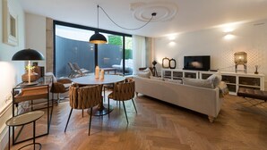 A modern living room with a dining area, a sofa, and a TV. - Classy & Stylish Porto Duplex (Porto)