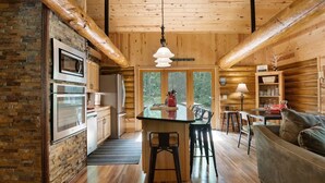 Ein modernes Holzblockhaus-Interieur mit Küche, Essbereich und Wohnzimmer.