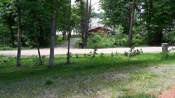 A wooden deck with a grassy area and trees.