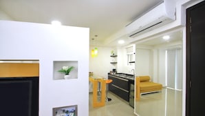 A modern kitchen with a central island, a dining area with a yellow chair, and a living room with a TV. - A spacious and fabulous   387 ft2 studio, near every thing in Cali (Cali)