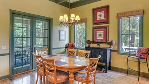 A dining area with a wooden table and chairs, a chandelier, and framed pictures on the wall. - 5 Mi to Old Town Bluffton: Cottage w/ Patio (Bluffton)