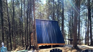 Metsäisessä ympäristössä sijaitseva viihtyisä ulkoalue, jossa on nuotiopaikka, piknikpöytiä ja Adirondack-tyylisiä puutarhatuoleja.