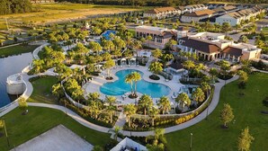 A resort with a large central pool, multiple guest buildings, and surrounding greenery. - Stunning 6-Bed Home - Sleeps 13 at Solara! (Kissimmee)