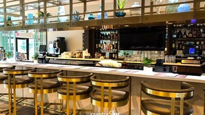 A bar area with multiple stools and a counter with a variety of bottles and a television screen. - Stunning 6-Bed Home - Sleeps 13 at Solara! (Kissimmee)