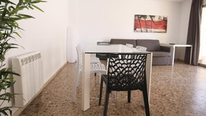 A modern living room with a glass table, white chairs, a grey sofa, and a painting on the wall. - 101-LARESMAN-MAGNIFICENT AND SPACIOUS APARTMENT JUST 2 MINUTES FROM THE BEACH (SALOU)