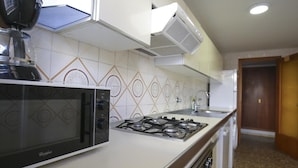 A kitchen with a gas stove, a microwave, and a built-in oven. - 101-LARESMAN-MAGNIFICENT AND SPACIOUS APARTMENT JUST 2 MINUTES FROM THE BEACH (SALOU)