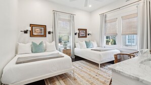 A bedroom with two beds, a ceiling fan, and a bathroom with a marble countertop. - 8B at Saint Philip Square, One Block to King, Spacious Group and Family Favorite (Charleston)