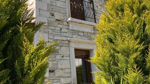 A stone building with a balcony, a window, and a door.