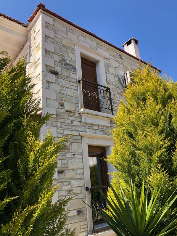 Un bâtiment en pierre doté d’un balcon, d’une fenêtre et d’une porte.