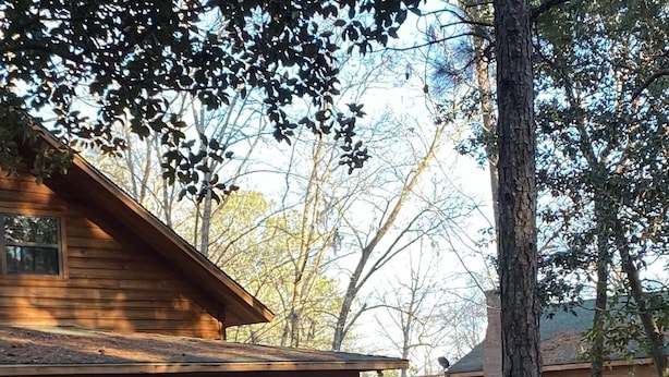 Une cabane en bois dotée d’un porche abrité et d’une petite terrasse.