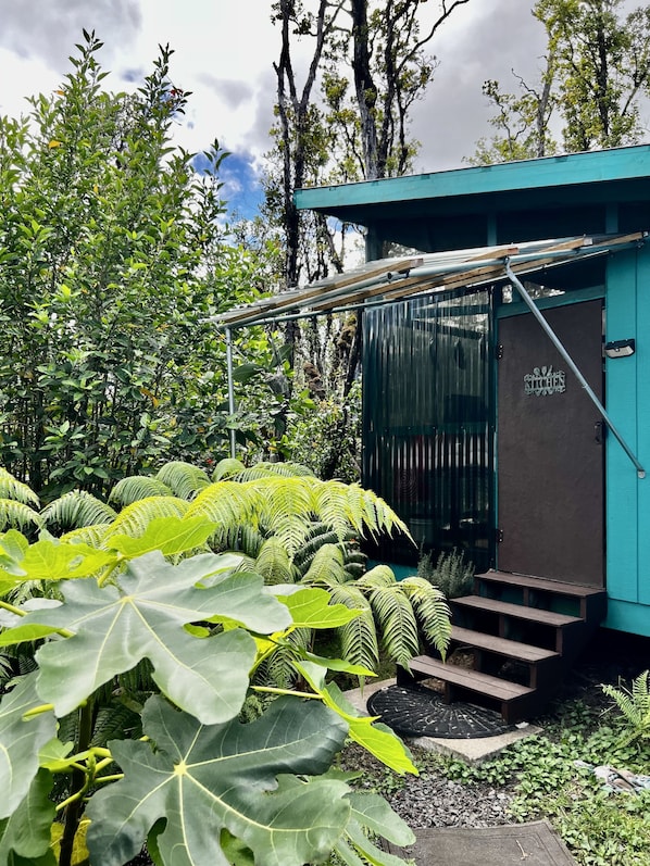 A small, rustic building with a sign reading "SILK KITCHEN" and a wooden staircase leading up to a door.