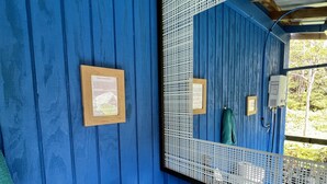 Un bany amb una paret de fusta blava, un lavabo negre, un mirall gran i un certificat emmarcat a la paret.