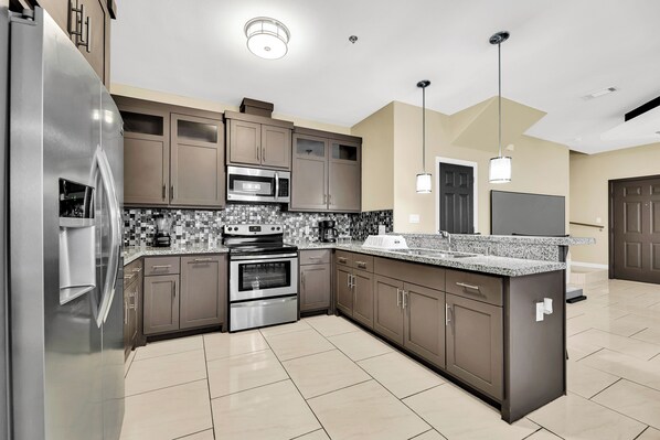 Enjoy cooking in this well-equipped kitchen with a large island, double oven, and sink.