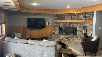 TV connectée, cheminée, livres, chaßne hi-fi