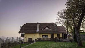 A two-story house with a sloped roof, a chimney, and a small porch.