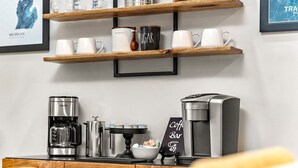 Un café équipé d’une machine à café Krups, d’un percolateur et d’une enseigne indiquant « Café ».