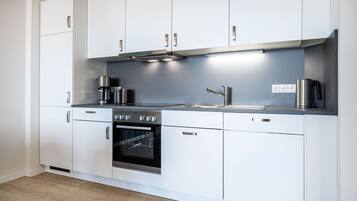 Een koelkast, een oven, een kookplaat, een vaatwasser