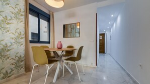 Un comedor con una mesa y sillas, un florero y un espejo montado en la pared.