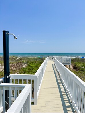 A wooden boardwalk leading to the beach with white railings and a metal lamp post. - Zoe's Family Tides!
Family Friendly Oceanfront. (Ocean Isle Beach)
