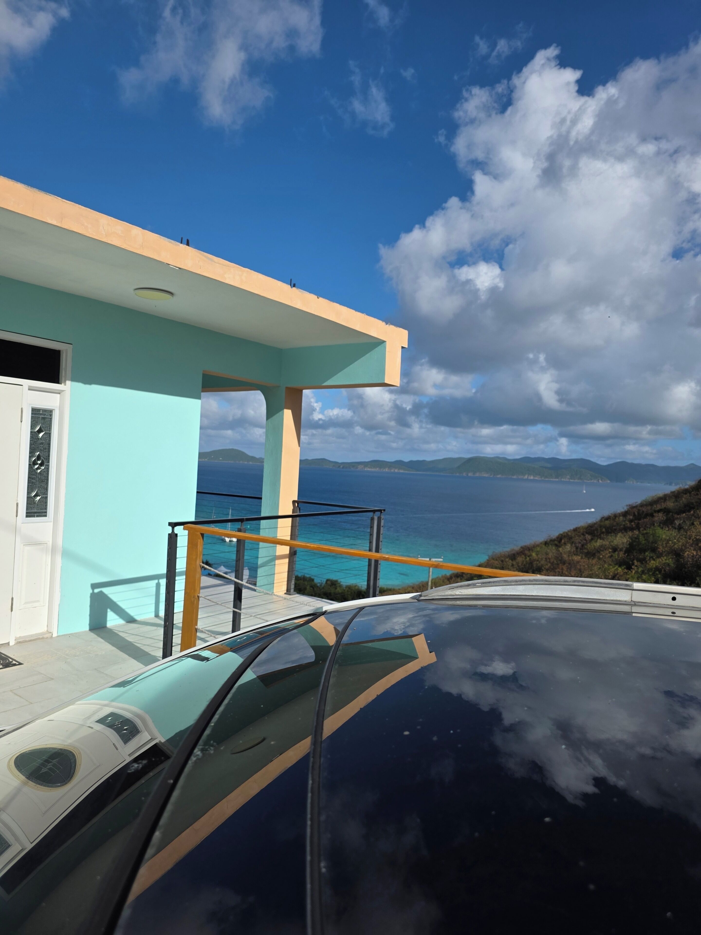 Un edificio moderno con balcón de cristal con vistas a la costa.