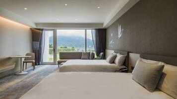 A hotel room with a large bed, a desk, and a view of mountains.