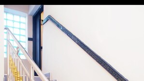 Una scala con ringhiere metalliche e balaustre dorate.
