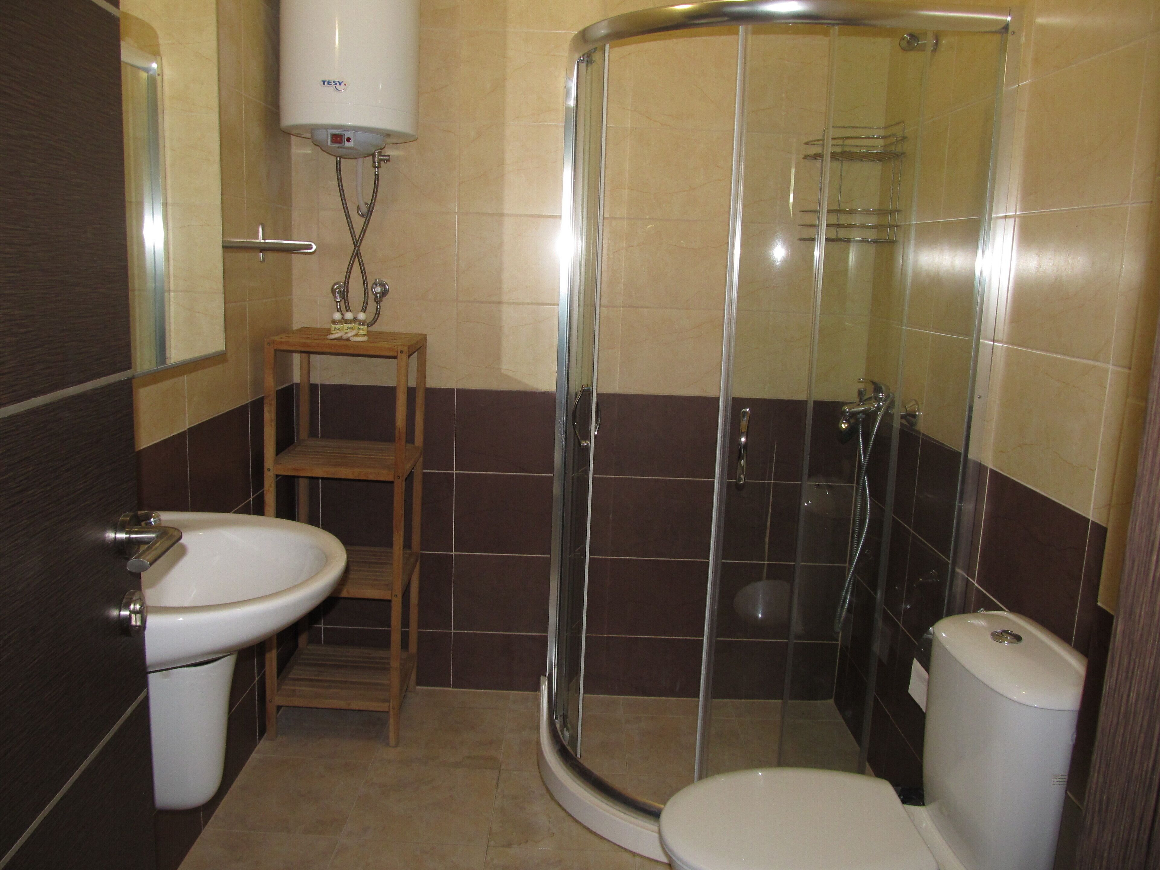 Un baño con inodoro, lavamanos y ducha.
