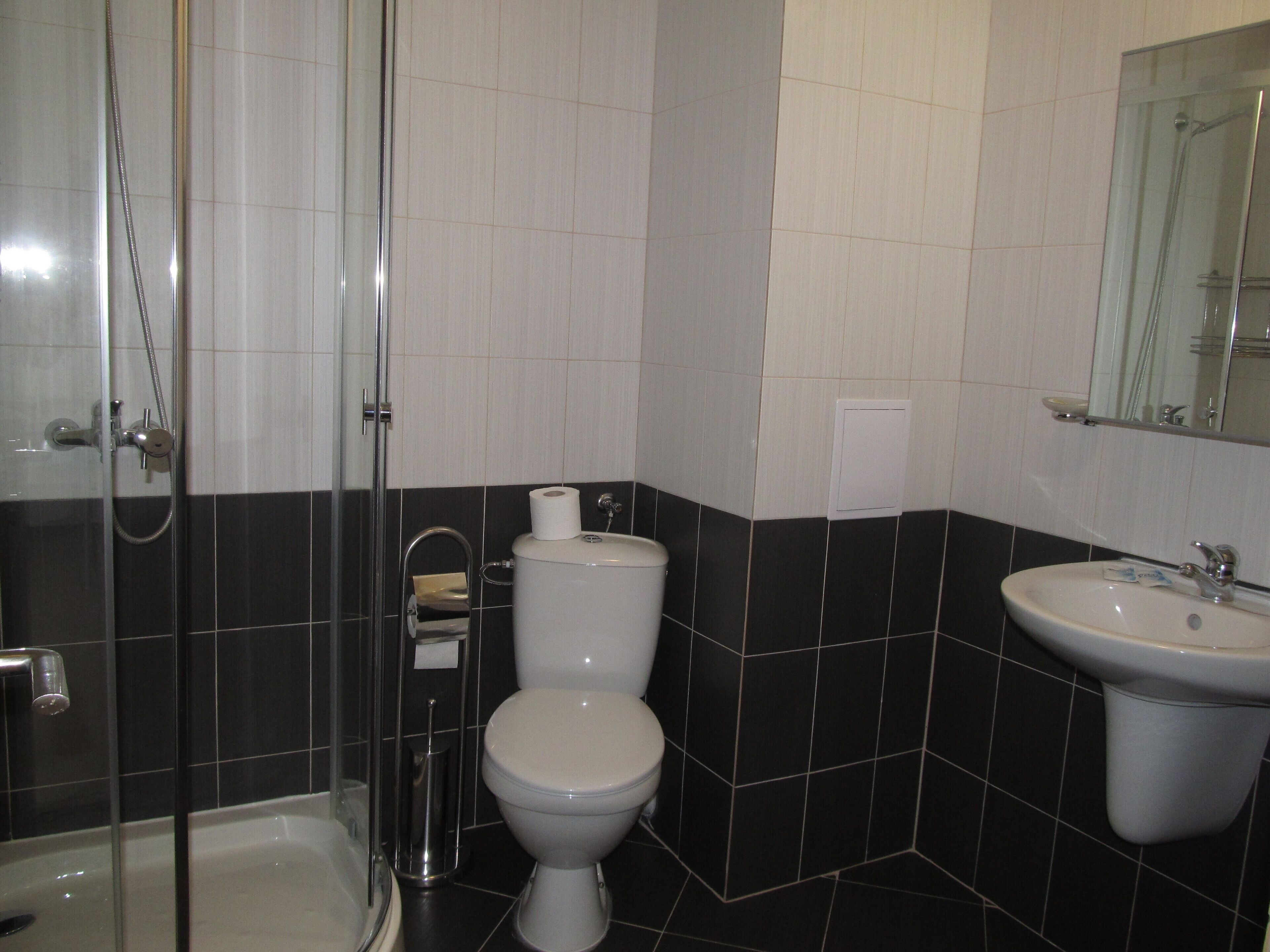 Un baño con ducha, inodoro y lavamanos.