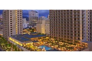 Enjoy panoramic city views from the rooftop pool area, surrounded by lounge spaces and dining options.