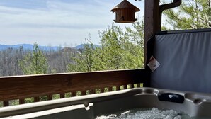 A hot tub with a wooden deck and a view of mountains and trees. - Luxury Mountaintop Getaway with, Fire Pit, New Hot Tub, WiFi & Gorgeous Views! (Sevierville)