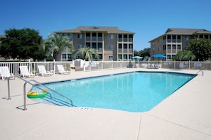 A rectangular swimming pool with a 3 FT depth marker, surrounded by white lounge chairs and a white fence.