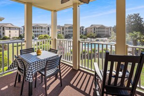 Relax in this serene outdoor space with a table for four and a view of the surrounding pool area.